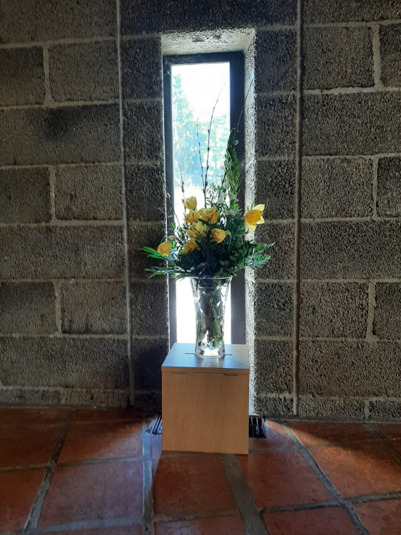 Huutoniemen kirkon kapea ikkuna, jossa kukkamaljakko ja kukat