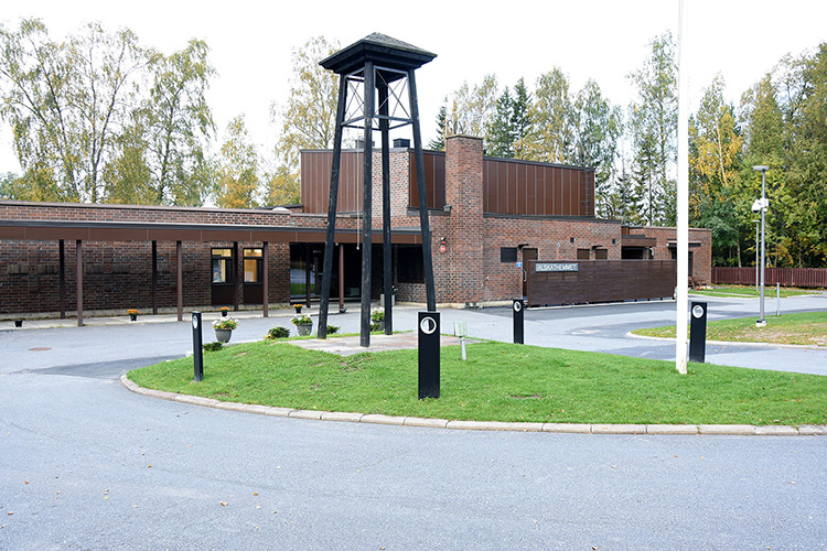 Alskathemmetin leirikeskus Iso tummanruskea tiilirakennus. Pihalla korkea kellotapuli.