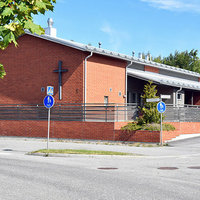 Metsäkallion seurakuntakoti Punainen tiilirakennus jossa risti seinällä