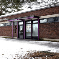 Ristinummen seurakuntakeskus Tummanruskea tiilirakennus. Maassa lunta.