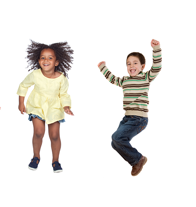 Kaksi kouluikäistä lasta hyppäävät iloisina tasajalkaa ilmaan.