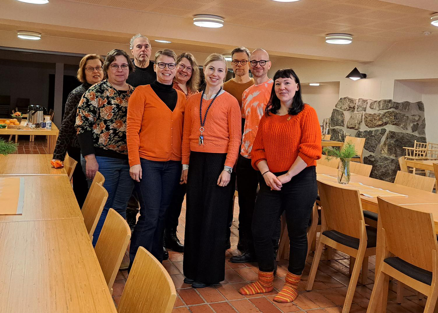 Ryhmäkuva koulutukseen osallistuneista oransseja vaatteita päällä